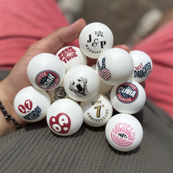 Fady holding a collection of personalized ping pong balls with various designs and text.