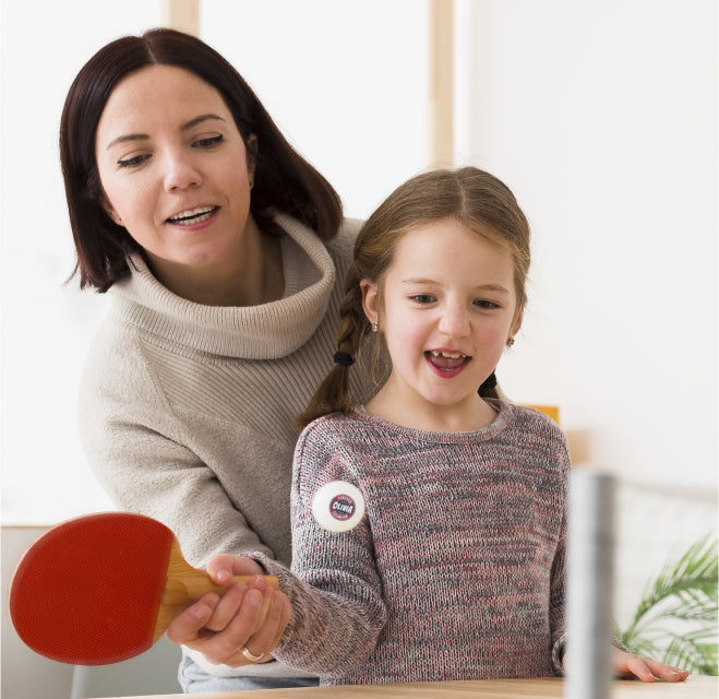 Woman and young girl playing table tennis with their new personalized ping pong ball with the name 'OLIVIA' on it
